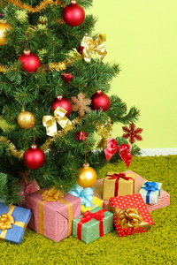 装饰圣诞树用绿墙背景上的礼物