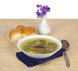 花瓶与紫罗兰 一盘蔬菜汤 一把勺子和一碟与表上的馅饼