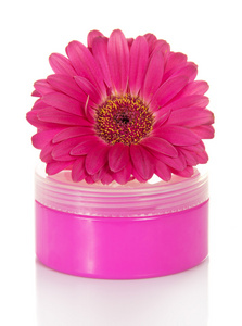在粉红色的容器和花卉非洲菊白色上孤立的美容霜