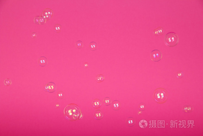 粉红色的背景上的透明肥皂泡沫