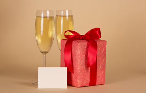 礼品盒用的弓 空卡和葡萄酒杯香槟，米色背景上