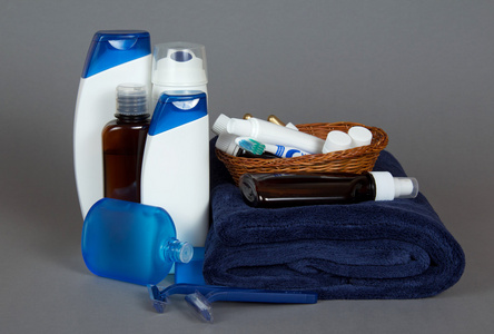 剃刀 洗剂 化妆品在一篮子和毛巾上以灰色背景中设置