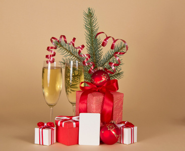 圣诞礼品 玩具 金属丝 杉木树分支 香槟和空卡 米色背景上
