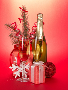 香槟酒瓶 酒杯 礼品 杉木树分支与红色背景上的金属丝
