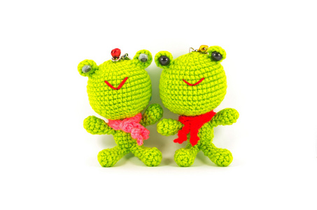 在白色背景上的手工钩针编织两个绿色的青蛙娃娃