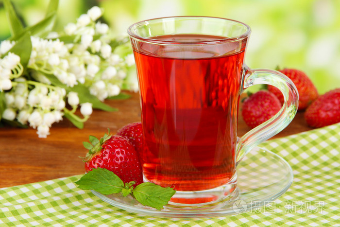 在明亮的背景上的桌上美味的草莓茶