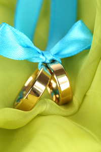 结婚戒指用明亮的织物上的缎带扎