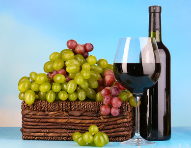 成熟的绿色和紫色葡萄在篮子里用自然背景上的木桌上的酒