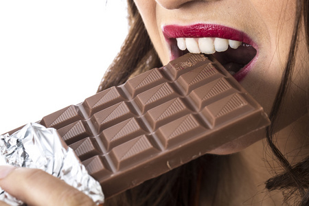 快乐的年轻女人吃巧克力