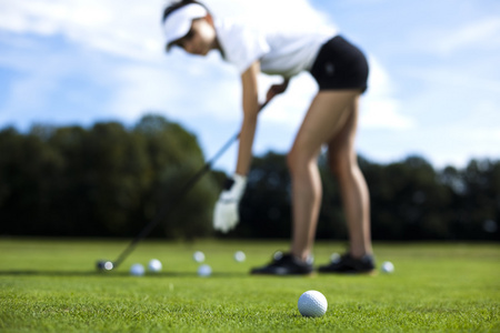 女孩在夏天在草地上玩高尔夫
