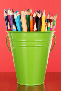 颜色桶与彩色铅笔 彩色背景上