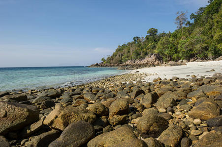 透过泰国高丽岛koh lipe清澈的海水，可以看到岩石沙滩和美丽的珊瑚。