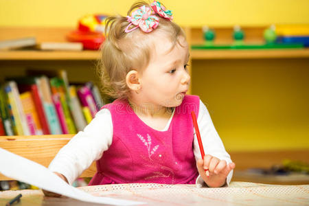 幼儿园里可爱的小女孩用彩色铅笔画画