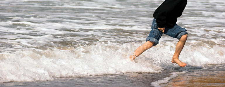 小男孩奔跑的脚海洋海滩冲浪撞击海泡沫