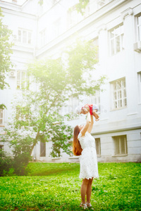 年轻的母亲在夏季公园和女儿玩耍