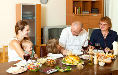 幸福三代一家在大桌子上吃鸡肉