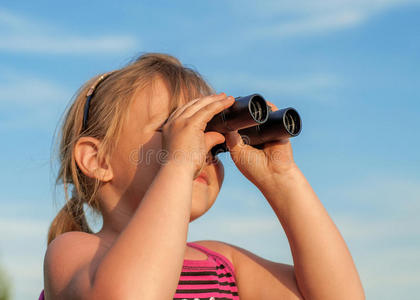 小女孩用双筒望远镜看