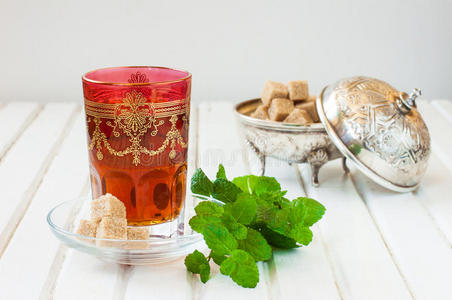 摩洛哥茶壶在一个白色的桌子上,一个茶壶,上面放着薄荷糖和糖的摩洛哥