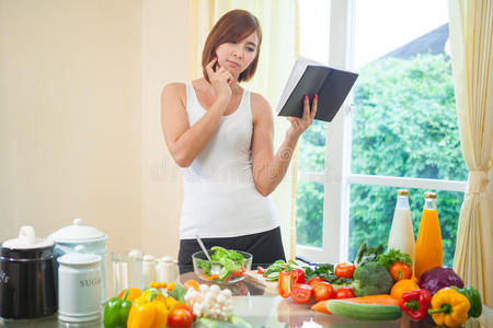 年轻女人读烹饪书