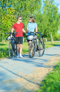 快乐的白人夫妇骑着自行车在自然环境中散步