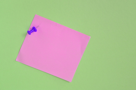 粉红色便条纸使用绿色背景上的 pin