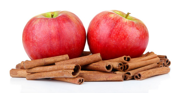 成熟的苹果与用肉桂棒上白色隔离
