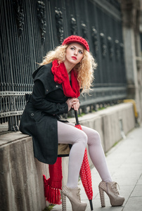 有魅力的年轻女人在冬季时尚射击。小红伞在街上的漂亮时尚年轻女孩