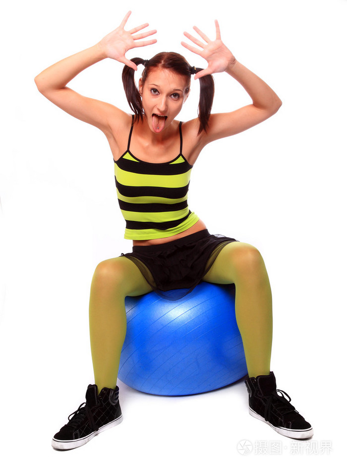 十几岁的女孩.做个鬼脸,坐在普拉提球