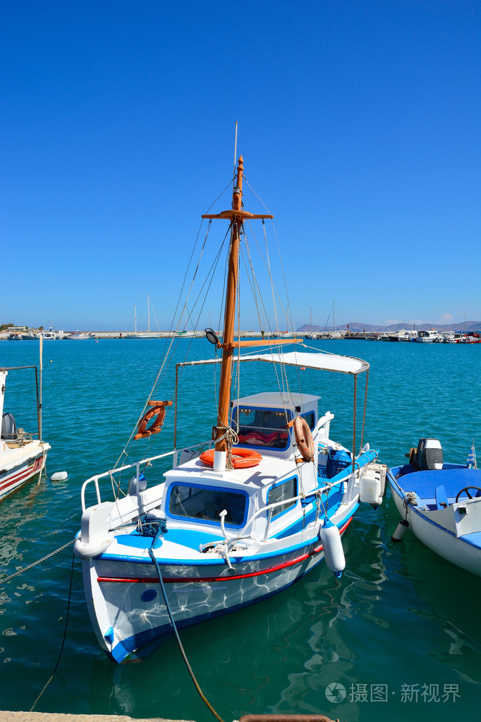 在白色和蓝色颜色的传统希腊船在海浪上梁咏琪在晴朗的一天