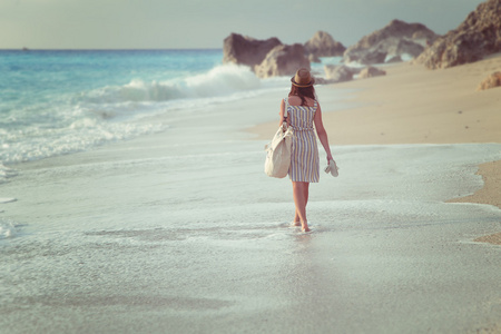 一个女孩走在沙滩上