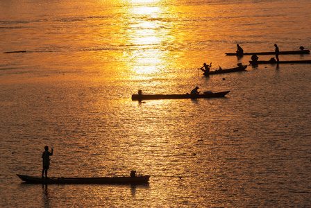 许多渔夫划划船捕鱼时日落，silh