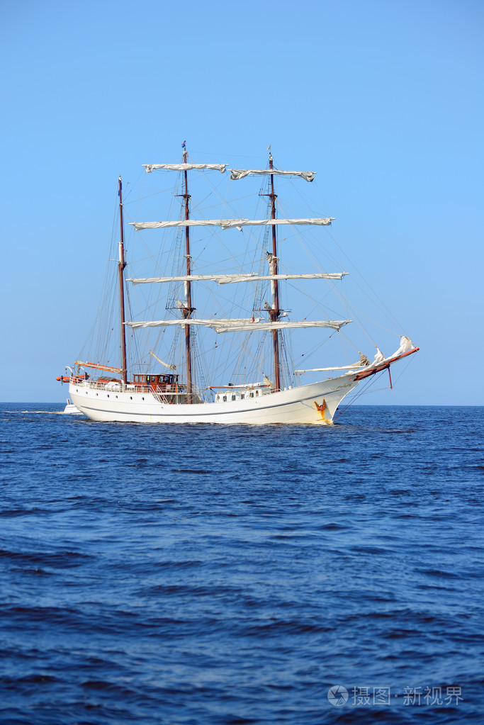 旧历史高船与白色风帆在蓝色的大海