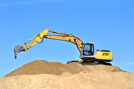 新黄色挖掘机沙丘上工作