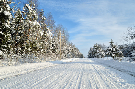 在阳光明媚的冬日农村道路。经典雪覆盖冬季景观