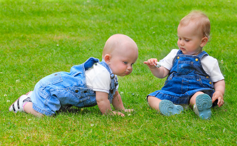 两个快乐的孩子在绿色草原上玩