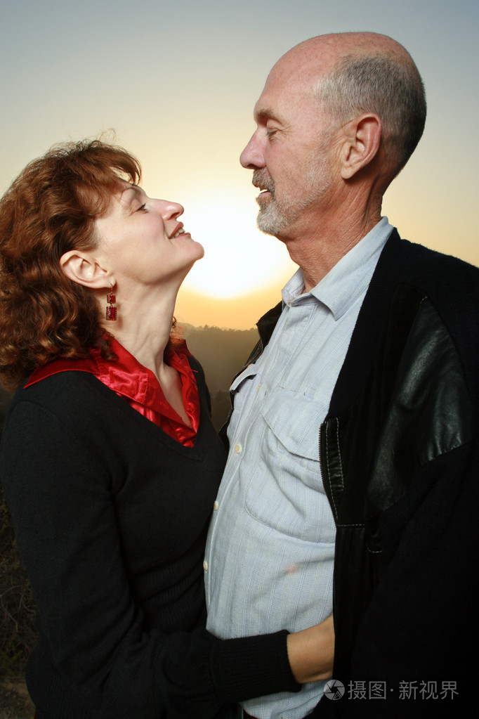 成熟两人深情相拥在日落时分