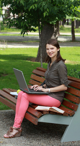 年轻女子在公园内的一台笔记本电脑