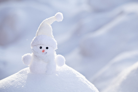 小小搞笑白色雪人在雪堆中照片