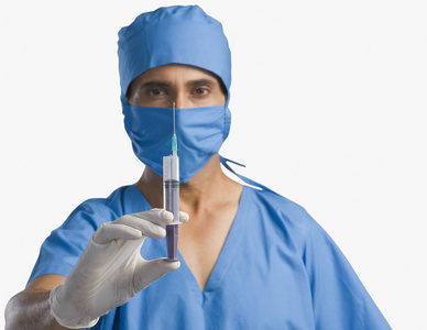 外科医生拿着一支注射器照片