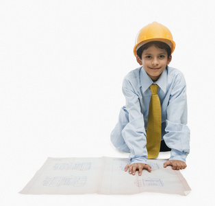 男孩打扮成一位建筑师和一张蓝图工作