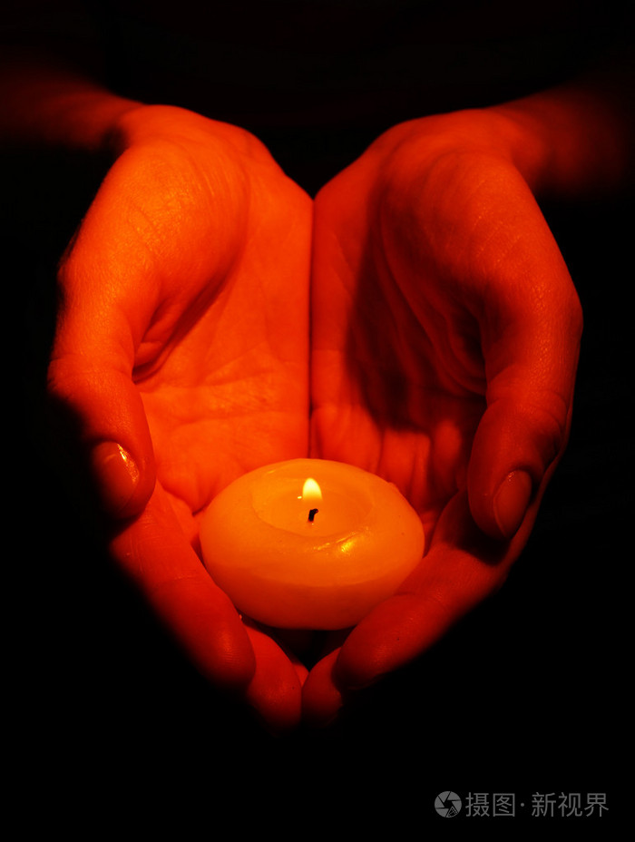 燃烧的蜡烛在手上黑色孤立