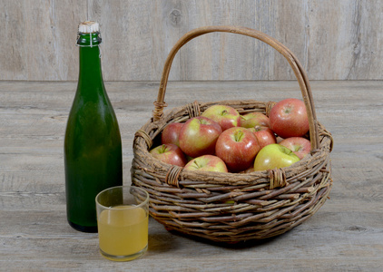 苹果篮和玻璃苹果酒的瓶子图片