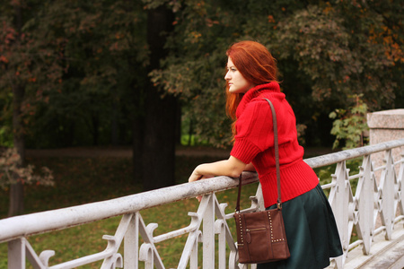时尚女人秋季公园一座桥上