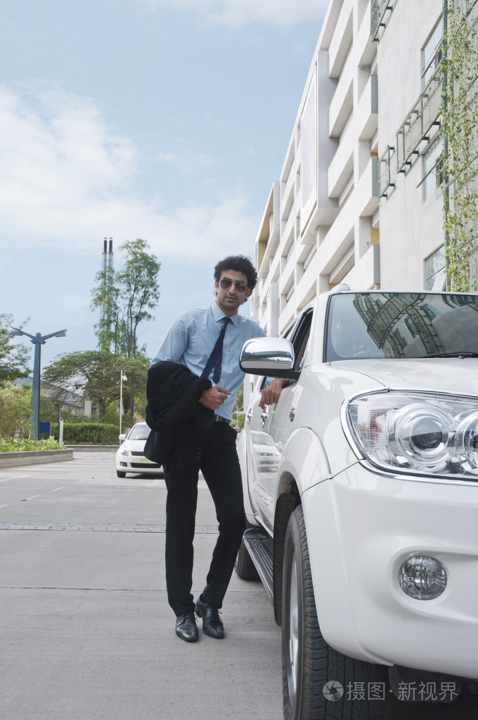 站在路边的一辆车旁边的商人照片-正版商用图片1dhdxn-摄图新视界