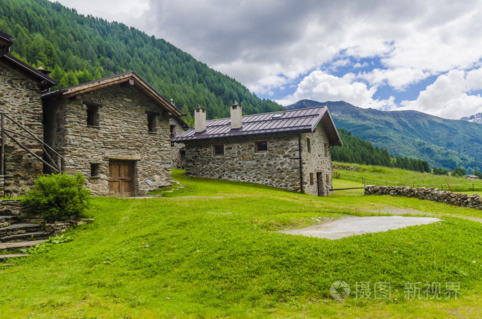 石牧羊人的村庄的房子里在四面环山的高山草甸.意大利北部