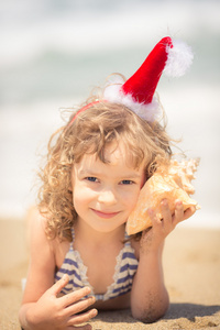 圣诞老人帽子在沙滩上的孩子