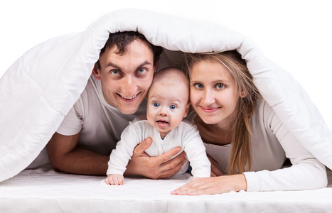 男婴在毯子下的年轻家庭