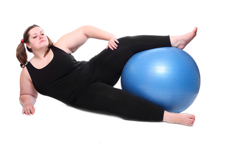拍摄的快乐超重的年轻女人与一个白色的背景上的蓝色球