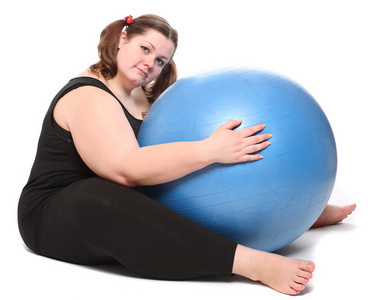 拍摄的快乐超重的年轻女人与一个白色的背景上的蓝色球