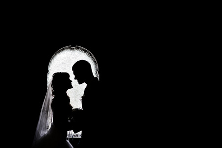 silhouettes 的新娘和新郎的拱门背景